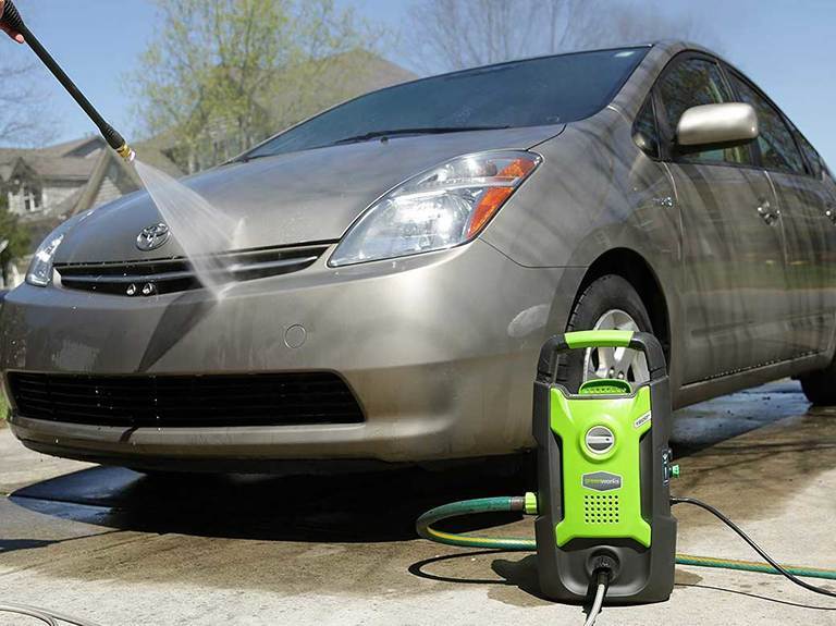 Greenworks pressure washer cleaning a car. Greenworks pressure washer cleaning a car.